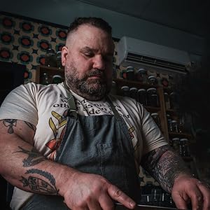 A person with short hair and a beard in an apron